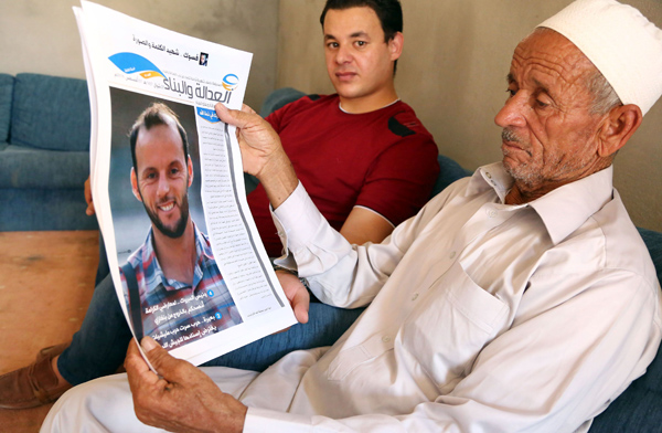Libyan Abdullah Ehmeda (right) shows a picture of his son Abdelqader, who died fighting alongside pro-Government of National Accord fighters in the battle against the Daesh terror group, during an interview on August 8 in Misrata, Libya (AP photo )