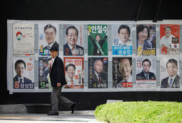 A man walks past posters of candidates for the upcoming presidential election in Seoul, South Korea, on Sunday (Reuters photo)