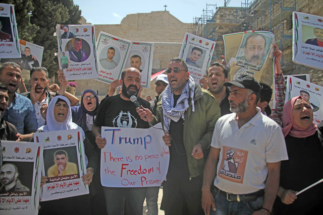 Palestinian demonstrators hold banners and posters during a demonstration in support of the Palestinian prisoners held in Israeli jails, outside the Mahd Church as US President Donald Trump meets Palestinian President Mahmoud Abbas in Bethlehem, West Bank, on Monday (Anadolu Agency photo)