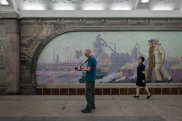 A tourist takes a photo during a visit to a subway station in Pyongyang on Sunday (AFP photo)