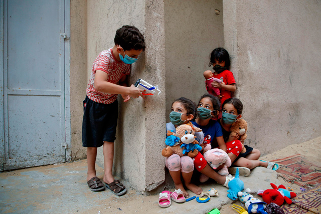 Palestinian children, mask-clad due to the COVID-19 coronavirus pandemic, play outside their house in Gaza City on September 8 (AFP photo)
