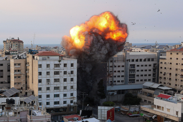 Fire and smoke rise after an Israeli air strike targeted the National Bank on Gaza City, on Sunday (AFP photo)