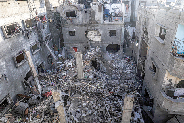 People inspect the rubble of a building destroyed by Israeli bombardment in Rafah in the southern Gaza Strip on Sunday amid the ongoing Israeli bombardment of the besieged enclave (AFP photo)