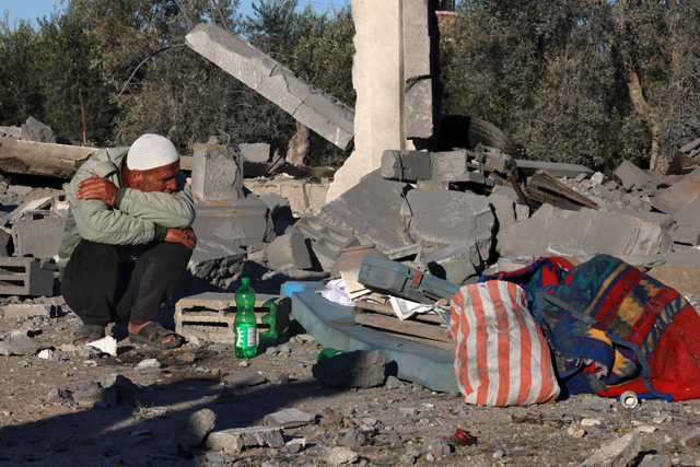 A man sits amid the rubble following Israeli bombardment in Rafah in the southern Gaza Strip on Saturday (AFP photo)