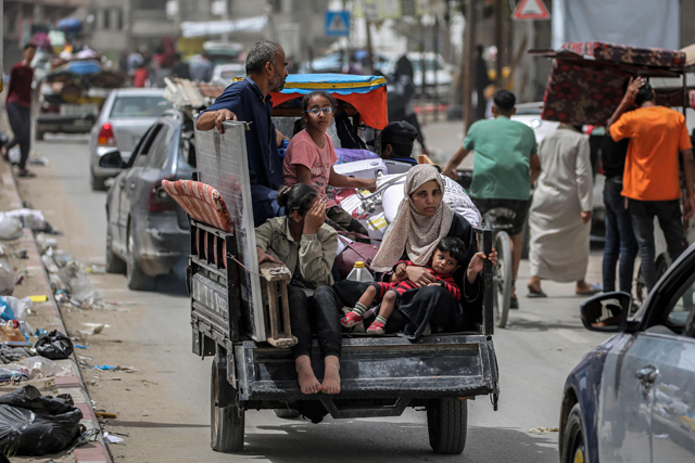 A man, woman, and children ride in the back of a tricycle loaded with belongings and other items as they flee bound for Khan Yunis, in Rafah in the southern Gaza Strip on Saturday amid the ongoing Israeli offensive against the Palestinian territory (AFP photo)