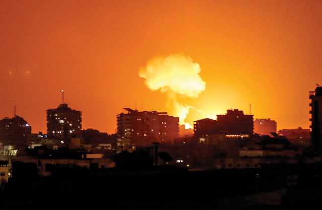 Smoke and flames rise after warplanes belonging to the Israeli occupation forces carried out air strikes over Gaza City on Tuesday (AFP photo)