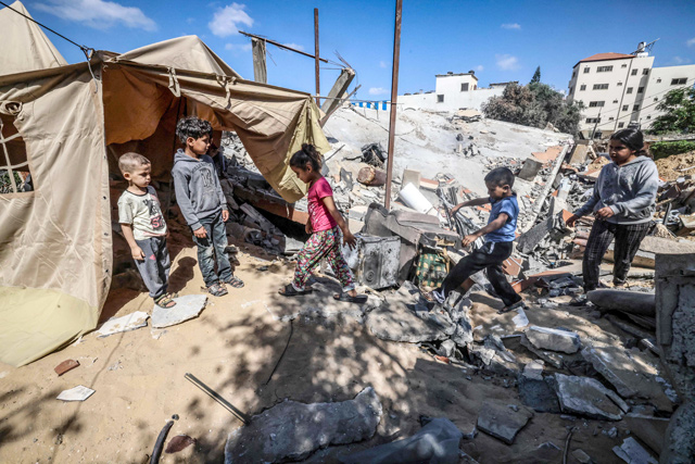 Children gather around a tent that Nazmy Al Dahdouh, a 70-year-old Palestinian man has set up on top of the ruins of his home, destroyed in recent Israeli air strikes in Gaza city, on Sunday (AFP photo)