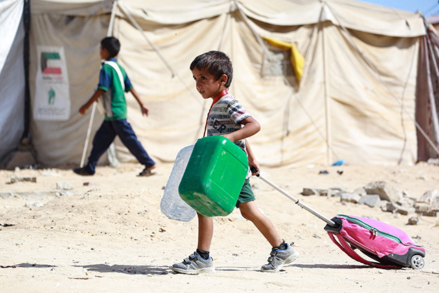 A Palestinian child drags along his bag as people flee the Hamad residential district and its surroundings in Khan Yunis in the southern Gaza Strip on Sunday, amid the ongoing Israeli war on Gaza (AFP photo)