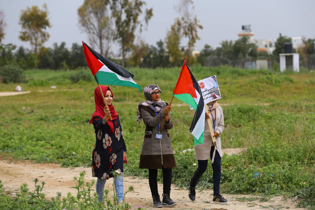 Palestinians hold banners during a rally marking Land Day near Beit Hanun in the northern Gaza Strip on Thursday (AFP photo)