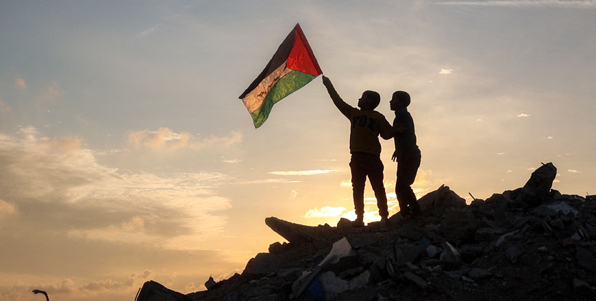 A boy runs with a Palestinian flag atop a mound of rubble at a camp for people displaced by conflict in Bureij in the central Gaza Strip on January 17, 2025 following the announcement of a truce amid the ongoing war between Israel and Hamas (AFP photo)