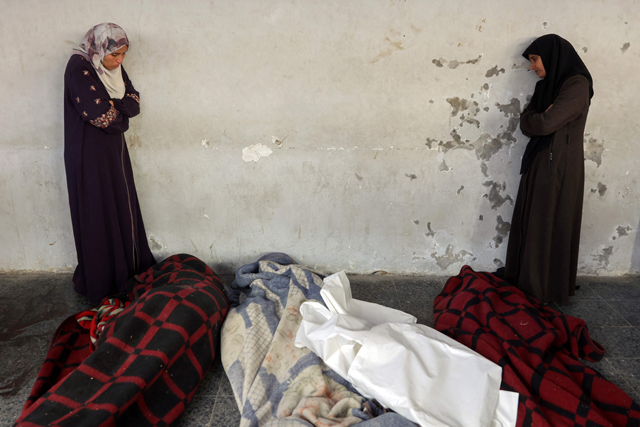 Women mourn next to bodies wrapped in blankets at a Baptist hospital morgue in Gaza City, on December 27, 2024, amid the ongoing Israeli war of aggression against the Palestinian territory (AFP photo)