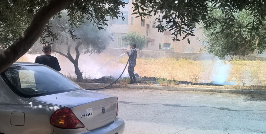 In this 2015 photo, Civil Defence Department personnel extinguish a fire that spread over dry grass in a plot of land in Amman (Photo by Hana Namrouqa)