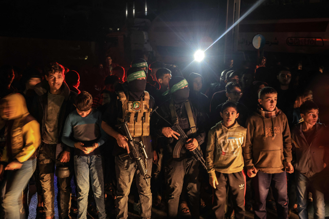 Children stand alongside fighters from the Al Qassam Brigades in Khan Yunis in the southern Gaza Strip on Wednesday, on the 6th day of a truce in battles between Israel and Hamas (AFP photo)