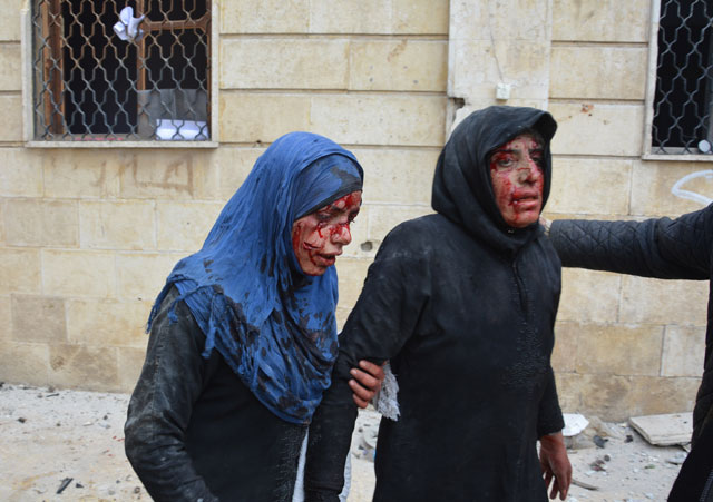 Two injured Syrian women are seen at the scene of blast after bomb-laden vehicle attacked the local courthouse in Azaz district of Aleppo, Syria, on Saturday (Anadolu photo)