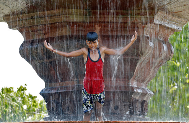 A boy plays in a fountain on a hot summer’s day in New Delhi, India, on Thursday (Reuters photo)