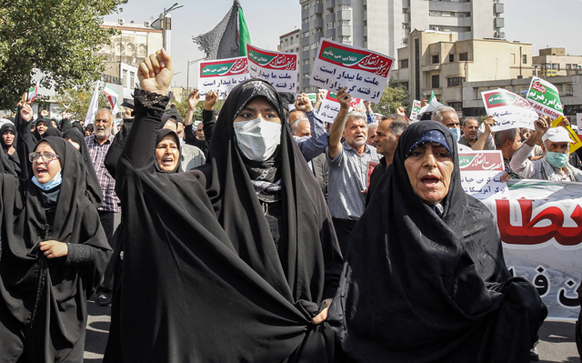 Women and men chant slogans as they march in a pro-hijab rally in Iran's capital Tehran on Friday (AFP photo)
