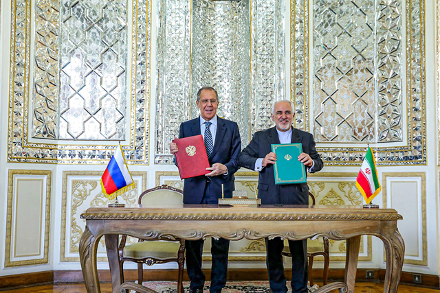 This handout photo provided by the Iranian foreign ministry on Tuesday shows Foreign Minister Mohammad Javad Zarif (right) and Russia's Foreign Minister Sergei Lavrov posing for a photo with exchanged documents during their meeting at the ministry headquarters in the capital Tehran (AFP photo)