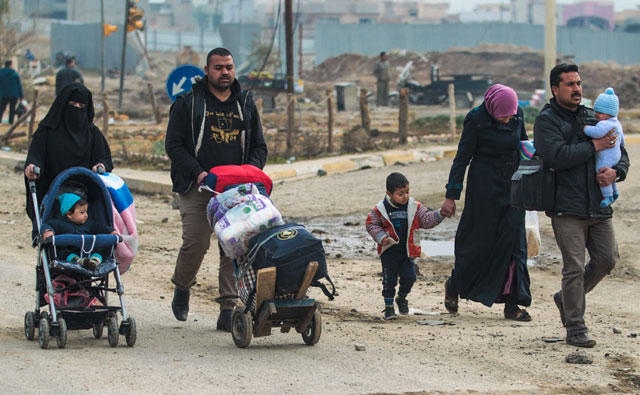 Iraqis walk on a street near the University of Mosul after its liberation from Daesh’s control, during the ongoing military operation against the extremists, on Saturday (AFP photo)