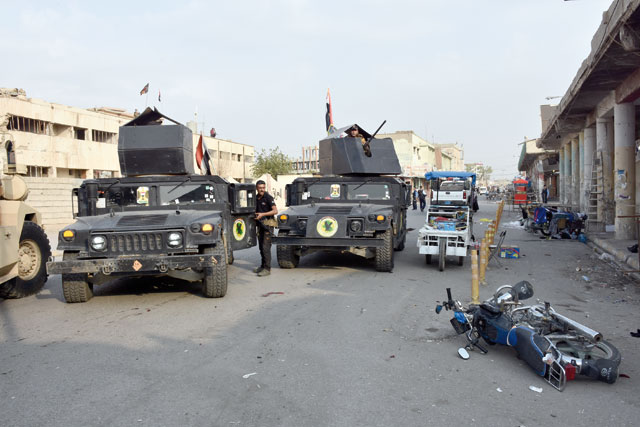 Police officers take security measures after a suicide bomber detonated his explosive vest in Atlas Street in Kirkuk, Iraq, on Sunday (Anadolu Agency photo)