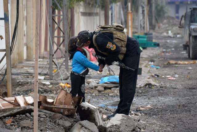 A member of Iraqi special forces kisses a child in the neighbourhood of Al Barid, east of Mosul, on Sunday during their ongoing operation against Daesh terror group militants to wrest back the city (AFP photo)