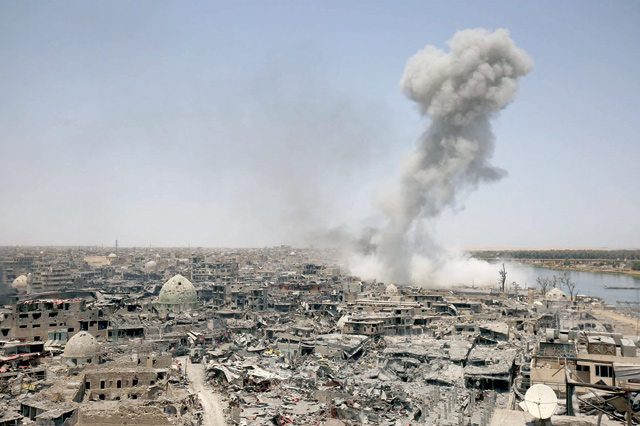 This file photo taken on July 9, 2017, shows smoke billowing following an air strike by US-led int'l coalition forces targeting the Daesh terror group in the northern Iraqi city of Mosul (AFP photo)