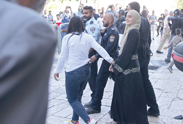 Israeli occupation forces transfer Palestinian activist Mona El Kurd, 23, out of a police station in Israeli-occupied East Jerusalem, on Sunday (AFP photo)