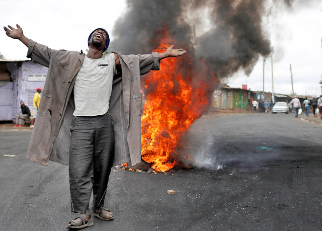 A supporter of opposition leader Raila Odinga gestures in front of a burned barricade in Kibera slum in Nairobi, Kenya, on Monday (Reuters photo)