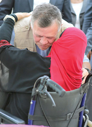 His Majesty King Abdullah is greeted by a woman with a disability at a town in the Northern Jordan Valley on Sunday (Photo courtesy of Royal Court)