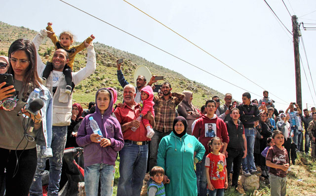 Syrian refugees wait to be evacuated from the southern Lebanese village of Shebaa on Wednesday, to return home to their village of Beit Jinn in the southwestern Damascus countryside (AFP photo)
