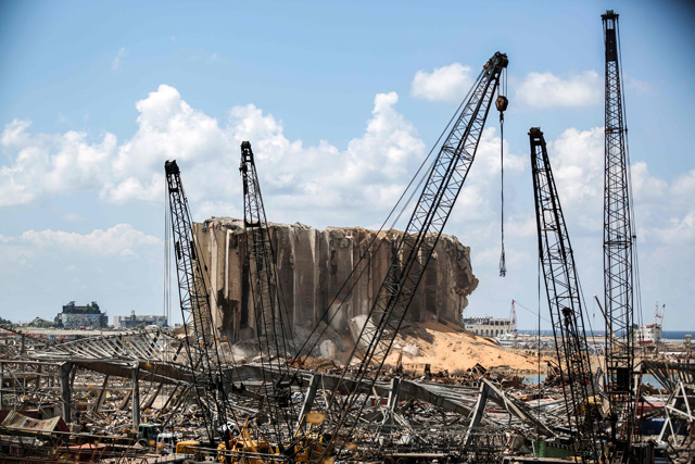 This photo taken on Sunday shows a view of the cranes at the port of Lebanon's capital Beirut, while in the background are seen the damaged grain silos opposite the blast site of a colossal explosion due to a huge pile of ammonium nitrate that had languished for years at a port warehouse (AFP photo)