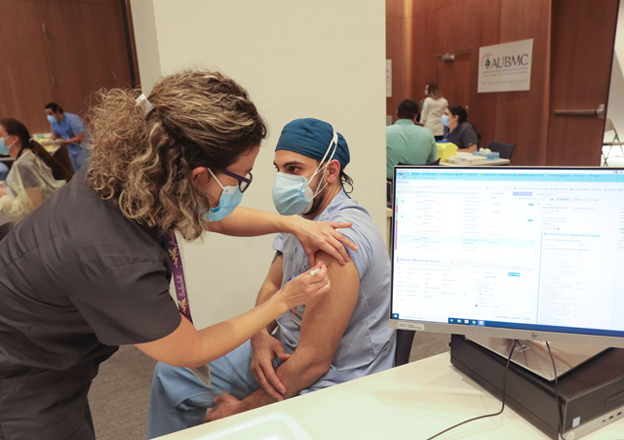 A member of the healthcare staff receives a dose of the COVID-19 Pfizer/BioNTech vaccine at Lebanon's American University Medical Centre in the capital Beirut, on Sunday, as the country kickstarts its inoculation campaign (AFP photo)