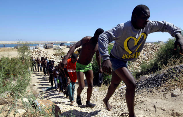 Migrants walk after they were rescued by Libyan coastguard at the coast of Gharaboli, east of Tripoli, Libya, on July 8 (Reuters photo)