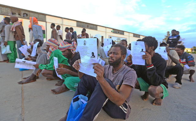 Nigerian migrants sit with their documents as they await to be repatriated, at a detention centre in the Libyan capital Tripoli's eastern suburb of Tajoura, on Tuesday (AFP photo)