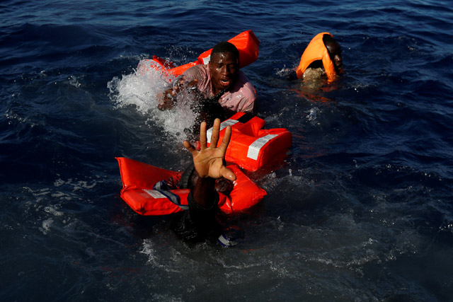 Migrants try to stay afloat after falling off their rubber dinghy during a rescue operation by the Malta-based NGO Migrant Offshore Aid Station ship in the central Mediterranean in international waters some 25km off the coast of Zawiya in Libya, Friday (Reuters photo)