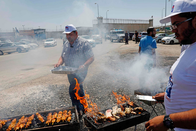 Israeli right-wing activists barbecue outside the Israeli-run Ofer military prison, north of Jerusalem, in the occupied West Bank, on Thursday, where a number of Palestinian prisoners are on a hunger strike (AFP photo)