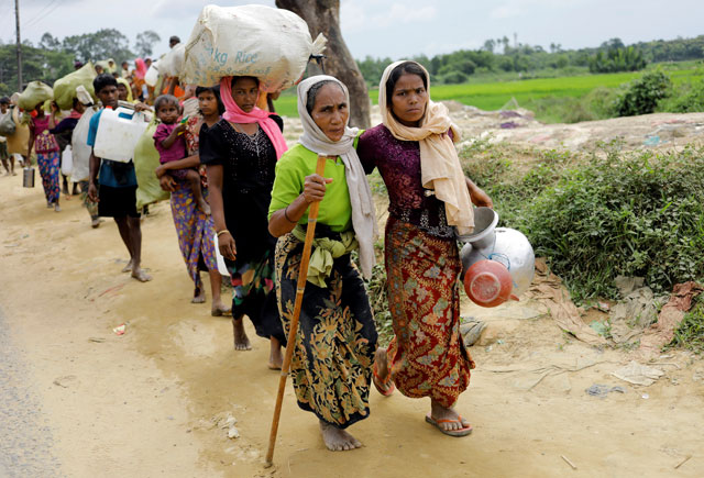 Rohingya refugees, who crossed the border from Myanmar two days earlier, walk after they received permission from the Bangladesh army to continue their way to Kutupalong refugee camp, near Cox's Bazar, Bangladesh, on Thursday (Reuters photo)