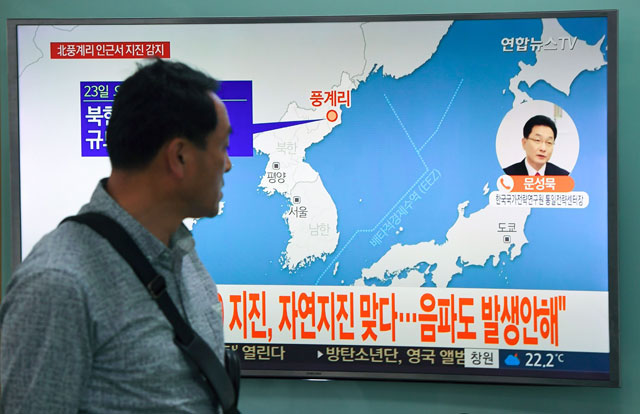 A man watches a television news screen showing a map of the epicentre of an earthquake in North Korea, at a railway station in Seoul, on Saturday (AFP photo)