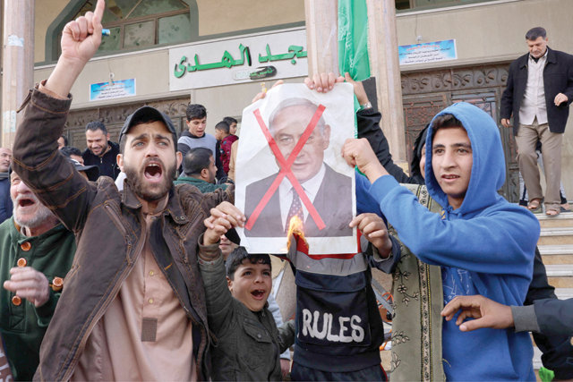 Palestinian protesters burn posters depicting Israeli Prime Minister Benjamin Netanyahu during a rally in Rafah in the southern Gaza Strip, on Friday (AFP photo)
