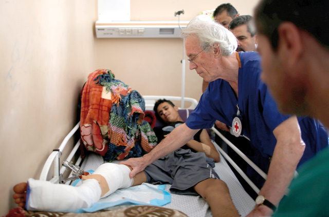 British vascular surgeon John Wolfe, who was invited to Gaza by the International Committee of the Red Cross, checks a wounded Palestinian in a hospital in Gaza City on Tuesday (Reuters photo)