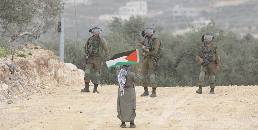 A Palestinian man confronts Israeli soldiers during a protest in the village of Beita, south of Nablus in the occupied West Bank, on Monday, against a march by settlers to the nearby Israeli outpost of Eviatar (AFP photo)