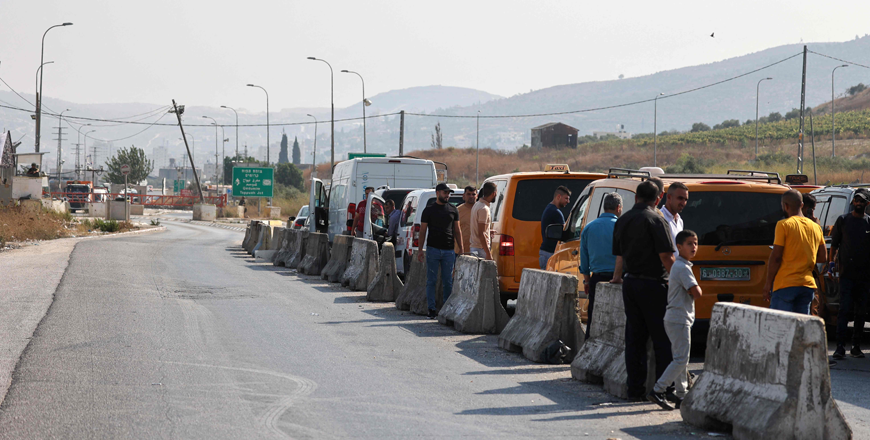 People wait by their cars after Israeli forces closed a road following a reported attack in the town of Huwara in the occupied West Bank, on Saturday (AFP photo)