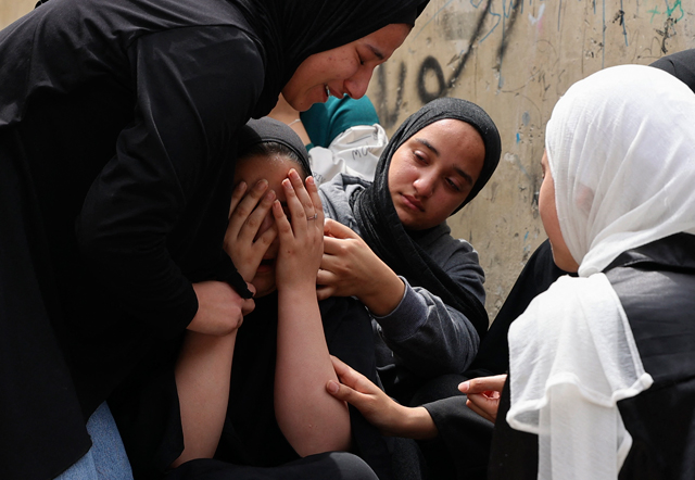 The sisters of 18-year-old Palestinian Amjad Al Fayed mourn his death, during his funeral in the refugee camp of Jenin, on Saturday (AFP photo)