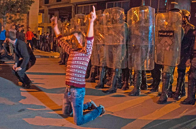 Demonstrators kneel before Moroccan police during a demonstration against corruption, repression and unemployment in the northern city of Al Hoceima on Saturday (AFP photo)