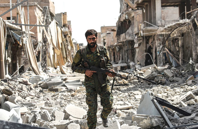 A member of the Syrian Democratic Forces walks through the debris in the old city centre on the eastern frontline of Raqqa on Monday (AFP photo)