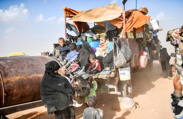 Syrians displaced from the city of Deir Ezzor prepare to leave the area where they are gathering to another location on the outskirts of Raqqa on Monday (AFP photo)