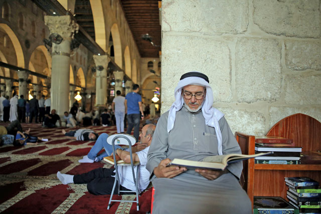 A Palestinian man reads the Koran in Al Aqsa Mosque during the holy month of Ramadan in Jerusalem's Old City on Monday (Reuters photo)