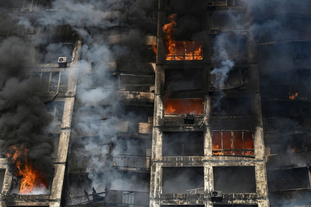 Firefighters extinguish a fire in an apartment building in Kyiv on Tuesday, after strikes on residential areas killed at least two people, Ukraine emergency services said as Russian troops intensified their attacks on the Ukrainian capital (AFP photo)
