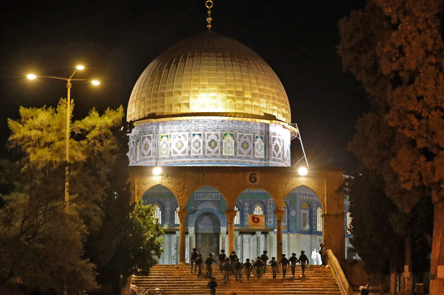 Israeli forces climb a stairway towards the Dome of the Rock Mosque amid clashes with Palestinian protesters at Al Aqsa Mosque compound in Jerusalem, on Friday (AFP photo)