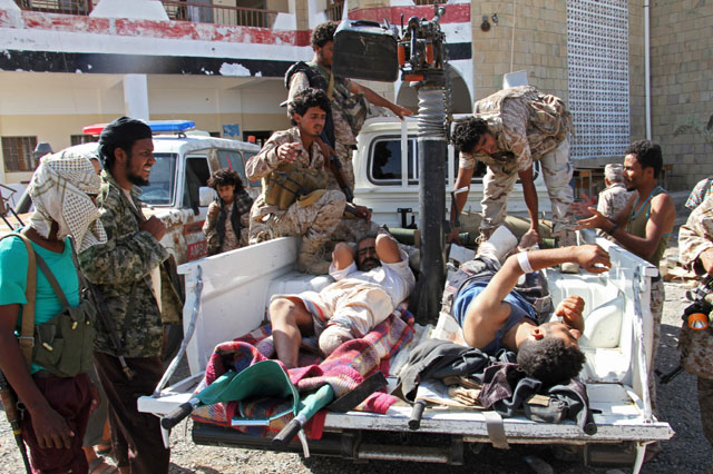 Fighters loyal to Yemeni president carry injured men onto the back of a pick-up truck in the western Yemeni coastal town of Mokha as they advance in a bid to try to drive the Shiite Houthi rebels away from the Red Sea coast on Saturday (AFP photo)