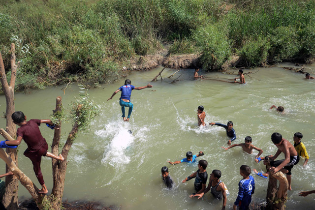 Iraqis taking shelter at Al Khazir camp swim in a river near the camp for internally displaced people, located between Erbil and Mosul, on Sunday (AFP photo)
